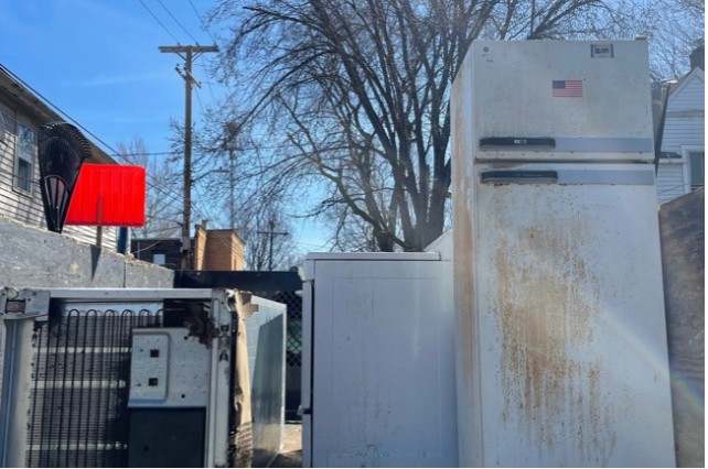 a truck bed that is full of appliances like refrigerators and stoves