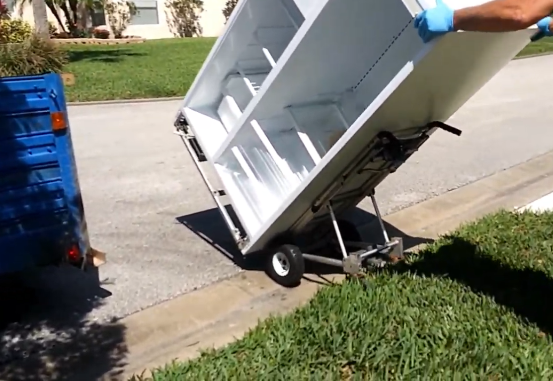 Refrigerator with no doors being wheeled away on a dolly