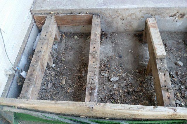 Overhead look at exposed beams from a deck that is currently being removed.