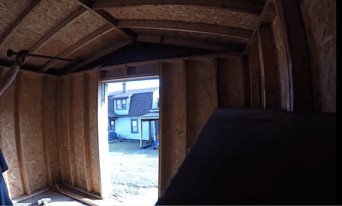 inside view of a shed that was just cleared out and about to be torn down. Through the doorway the outside of the owner's home is visible