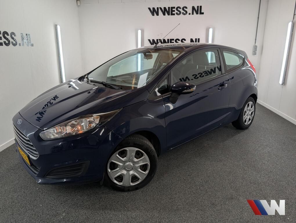 Donkerblauwe compacte hatchback in een showroom met WWNSS.NL-logo op de muur.