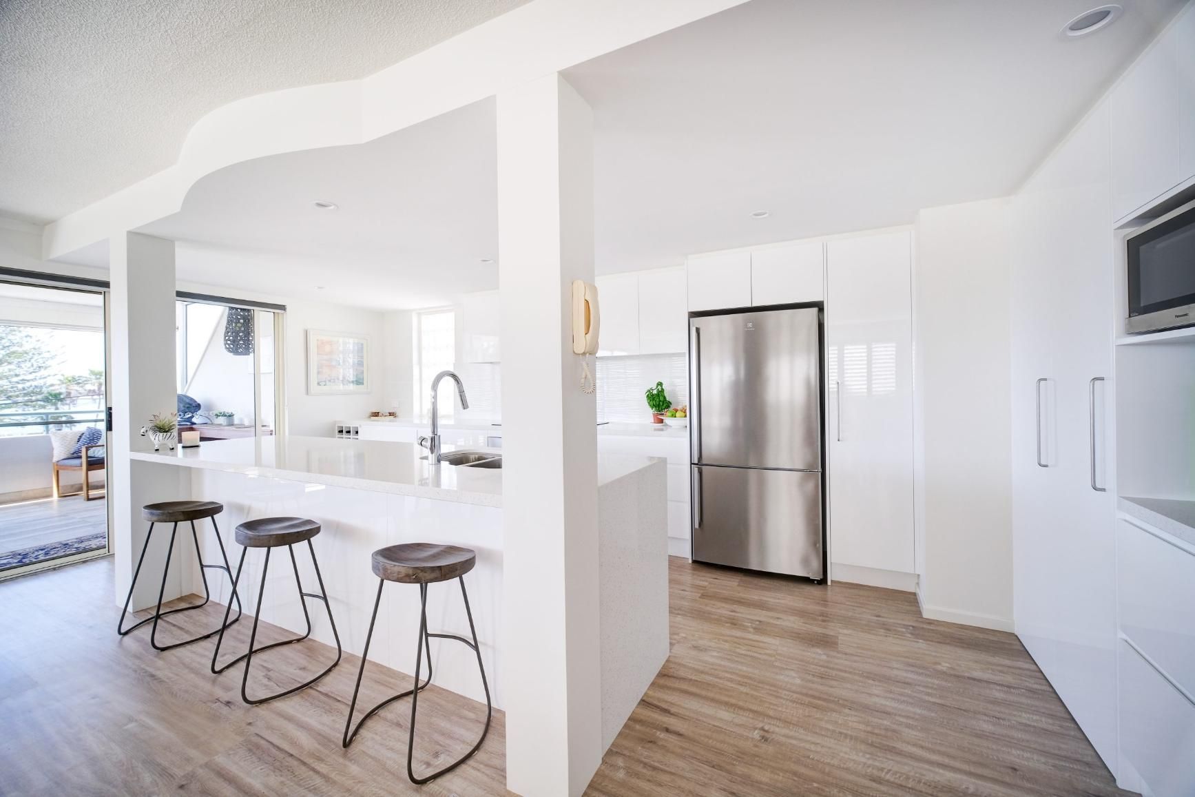 A Kitchen With White Cabinets And A Stainless Steel Refrigerator — Viison Kitchens & Joinery Forster In Forster, NSW