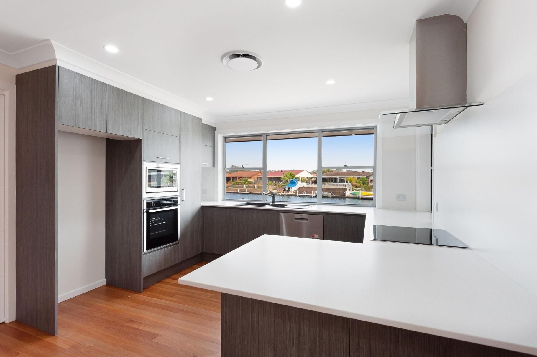 An Empty Kitchen With A Large Island And A Stove Top Oven — Viison Kitchens & Joinery Forster In Forster, NSW