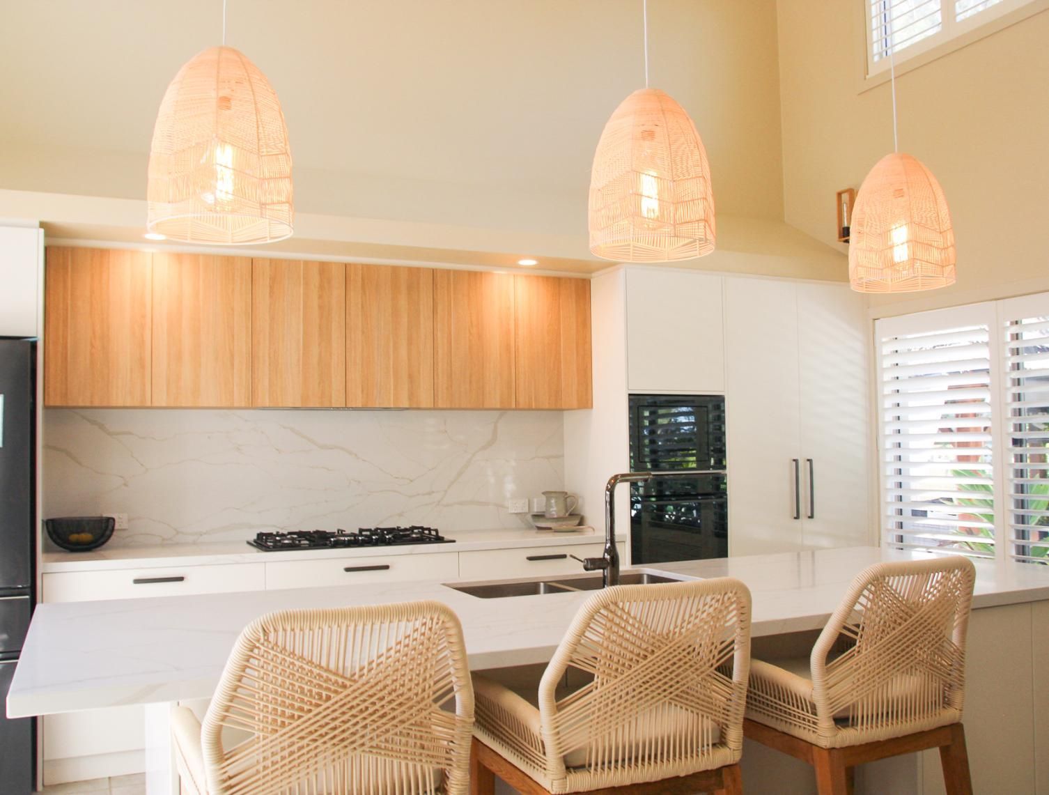 A Kitchen With White Cabinets And Wicker Chairs — Viison Kitchens & Joinery Forster In Forster, NSW