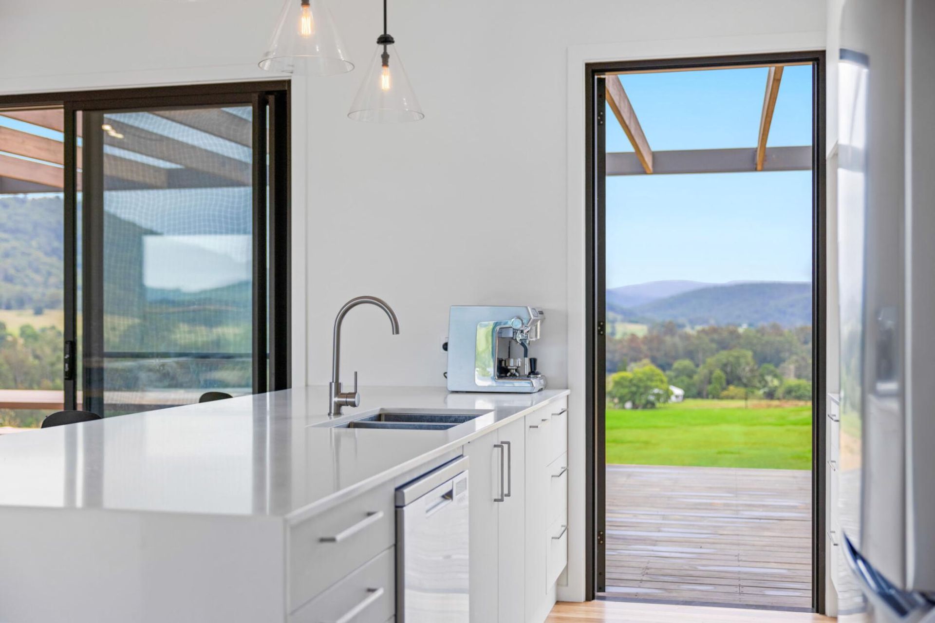 A Kitchen With A Sliding Glass Door And A View Of A Field — Viison Kitchens & Joinery Forster In Forster, NSW