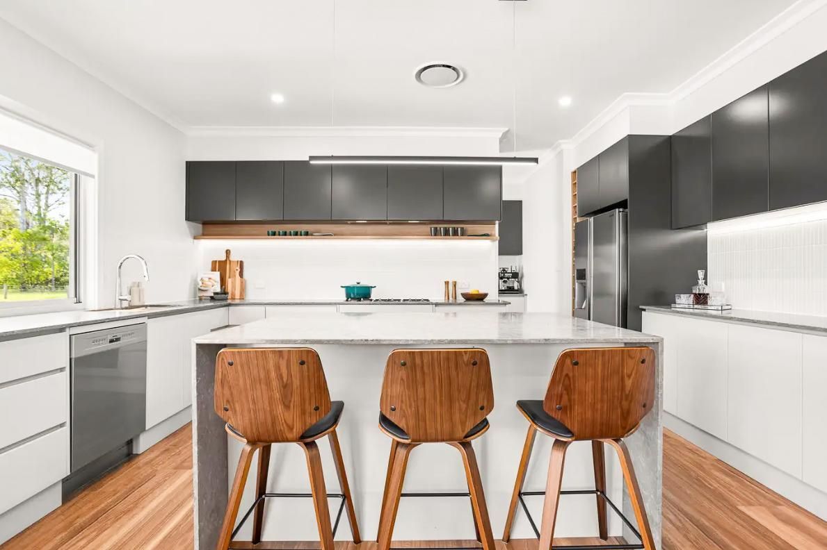 A Kitchen With A Large Island And Three Wooden Stools — Viison Kitchens & Joinery Forster In Forster, NSW