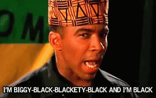 Man in patterned headwear and black jacket yelling,