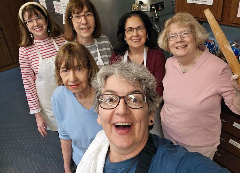 A group of women are posing for a selfie in a kitchen.