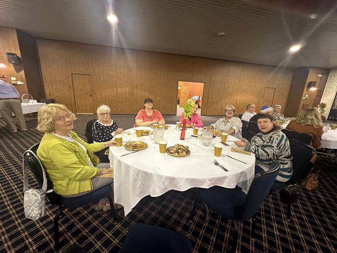 A group of people are sitting around a table eating food.