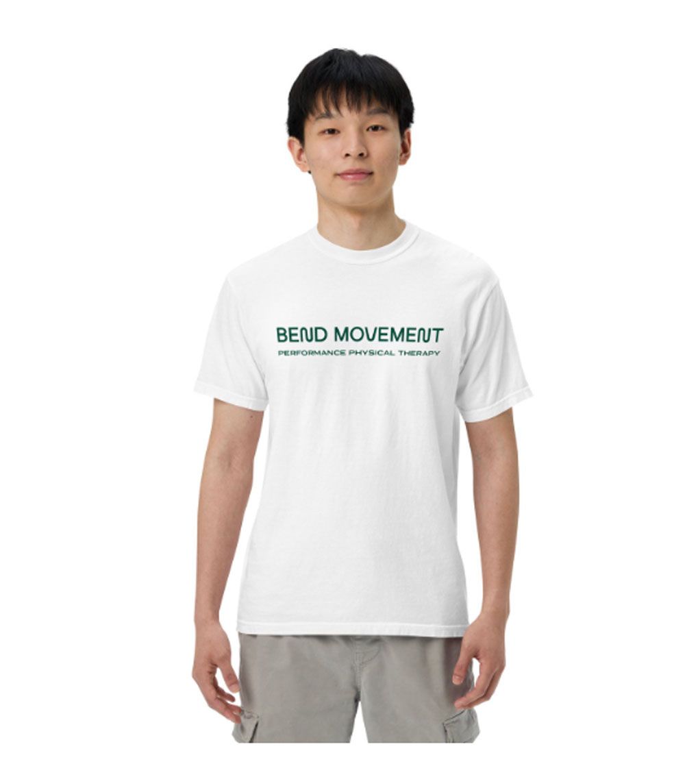 Man wearing a white graphic T-shirt and gray shorts against a plain white background
