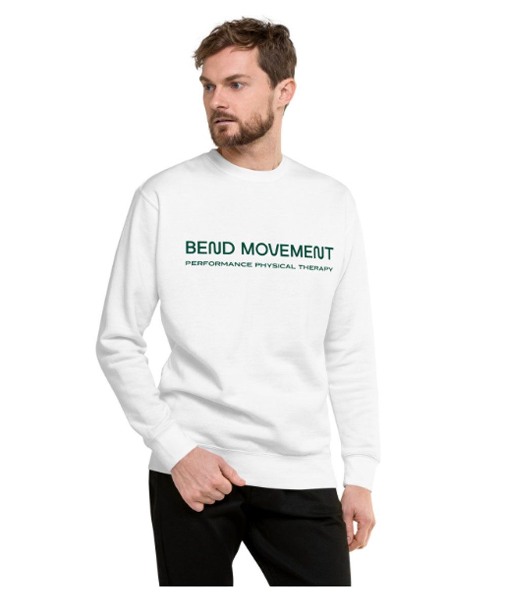 Man wearing a white sweatshirt with green text, standing against a white background