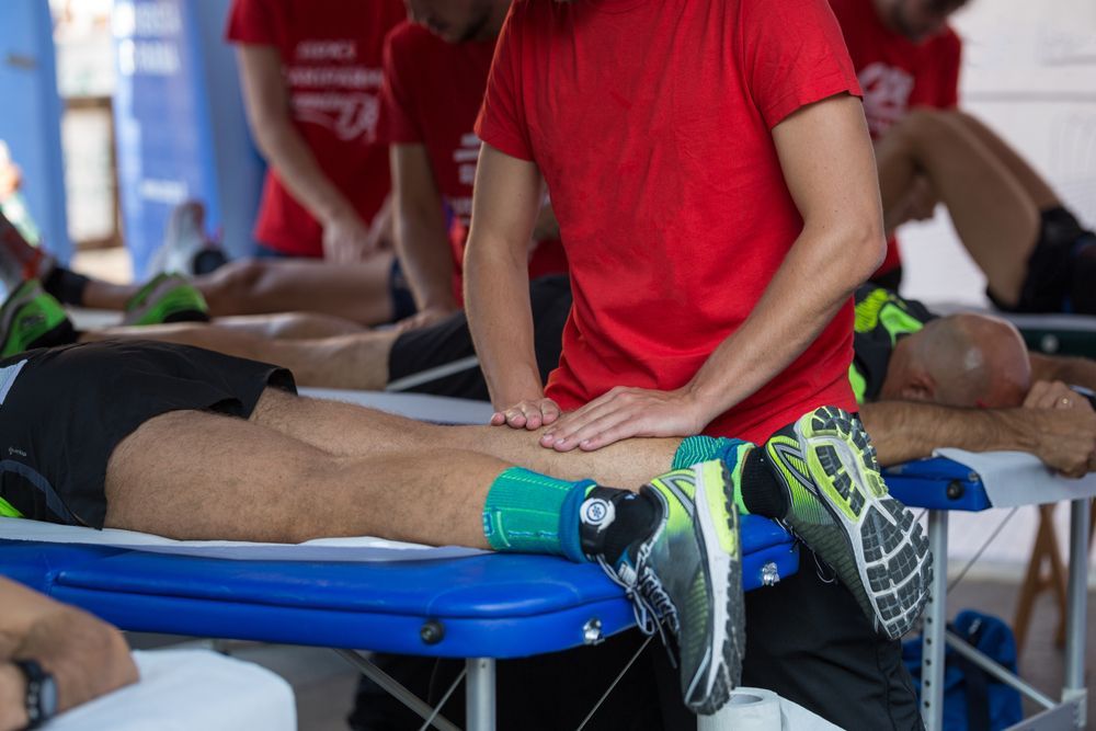 Athlete lying on a bed while getting a massage.
