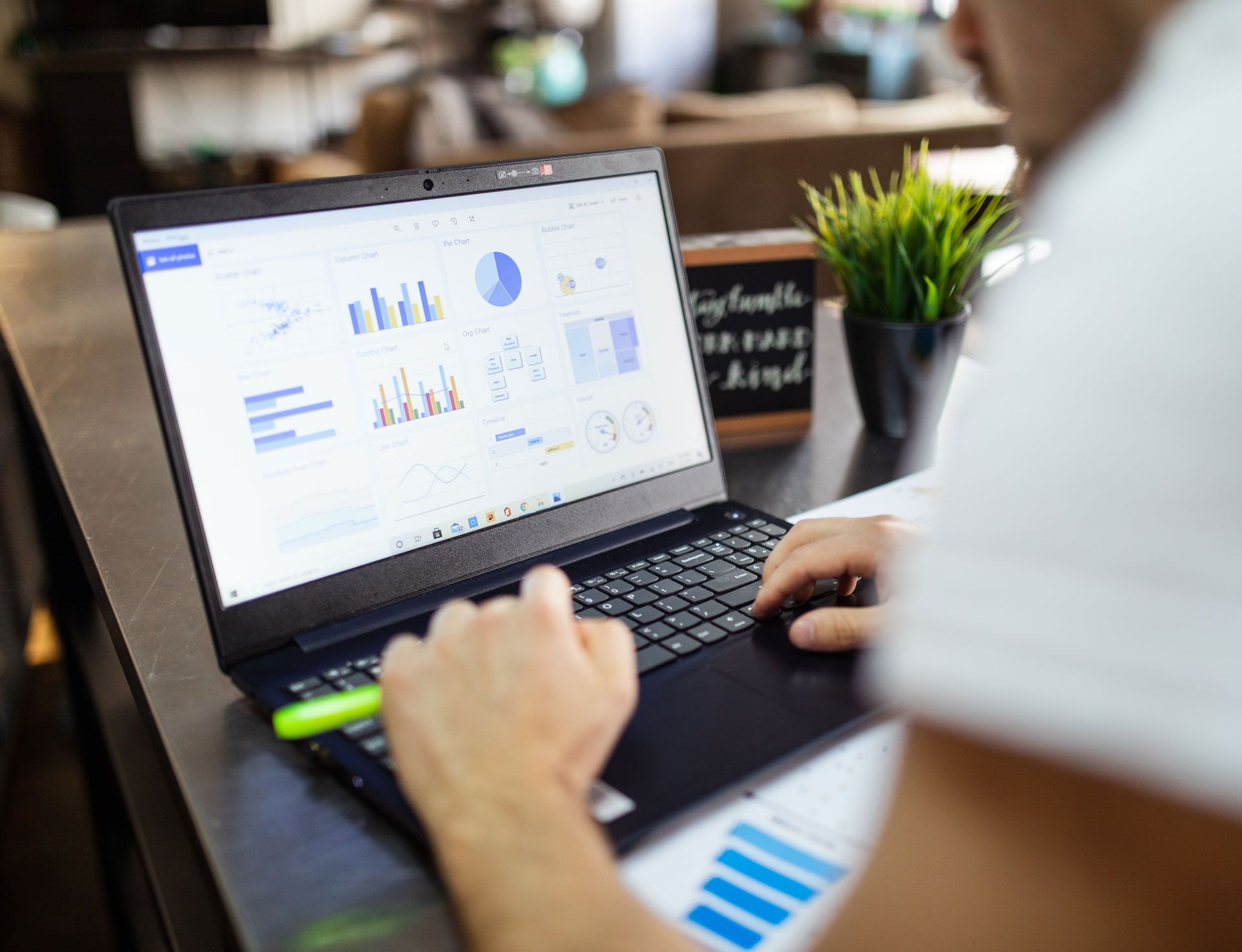 Person using a laptop, viewing charts and graphs, in a casual setting.