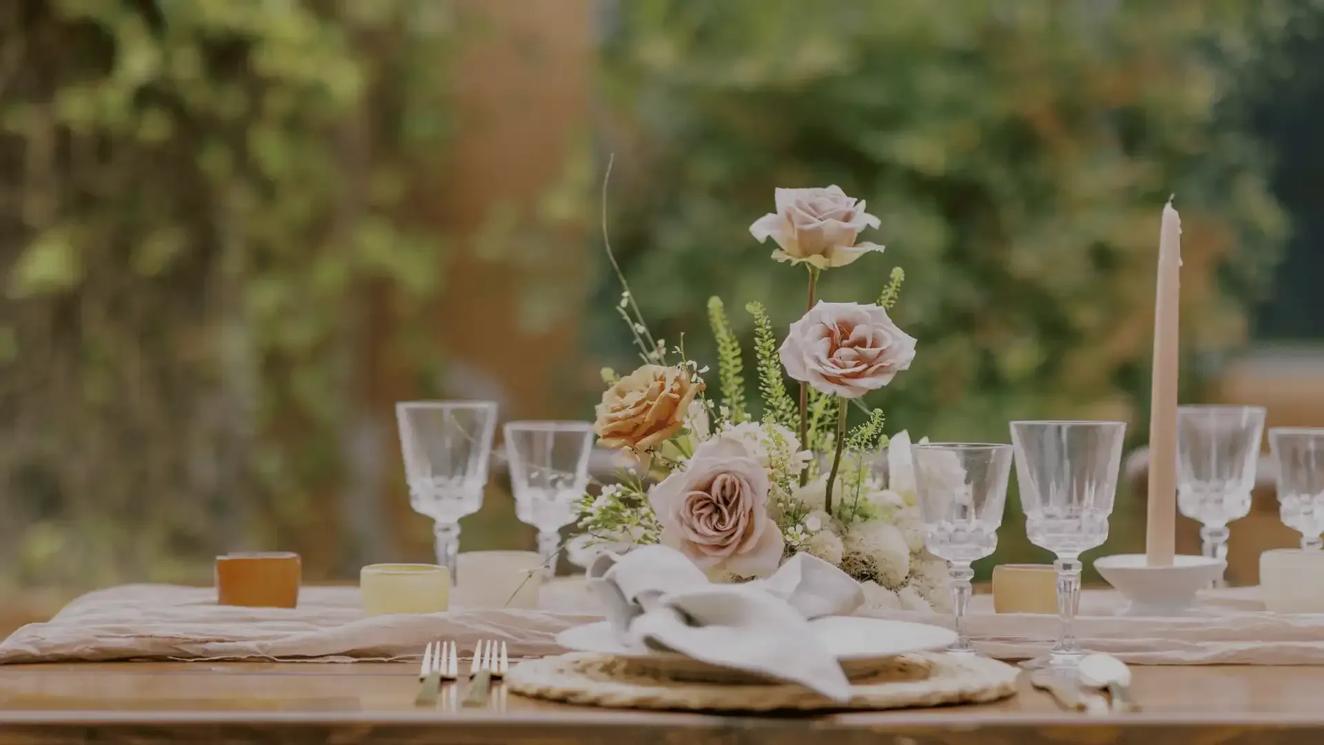 A table set for a wedding reception with flowers and wine glasses.