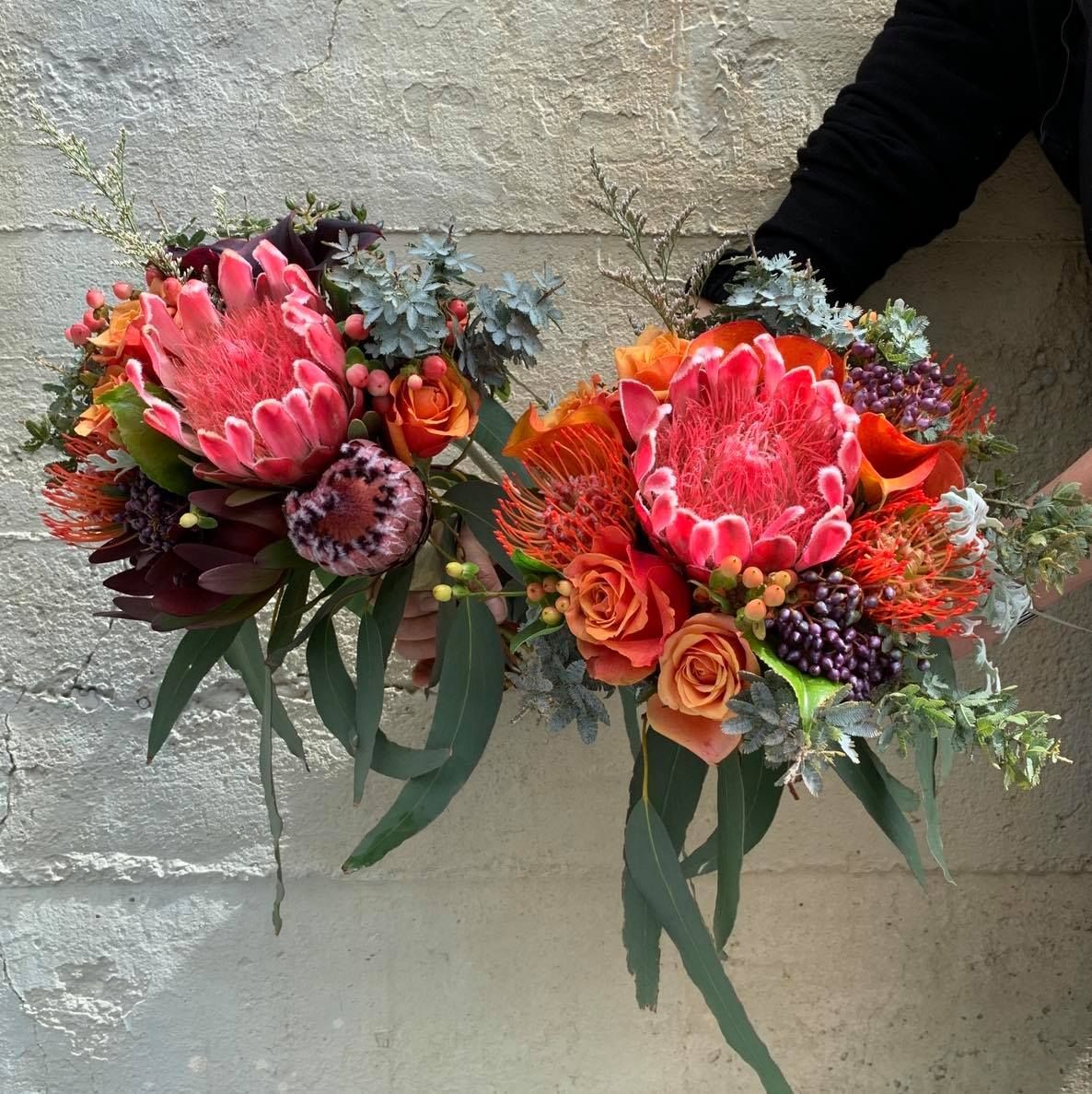a person is holding two bouquets of flowers in their hands
