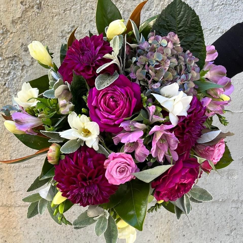 a person is holding a bouquet of pink and white flowers