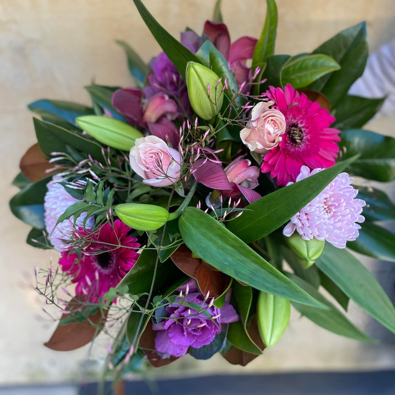a bouquet of pink and purple flowers with green leaves
