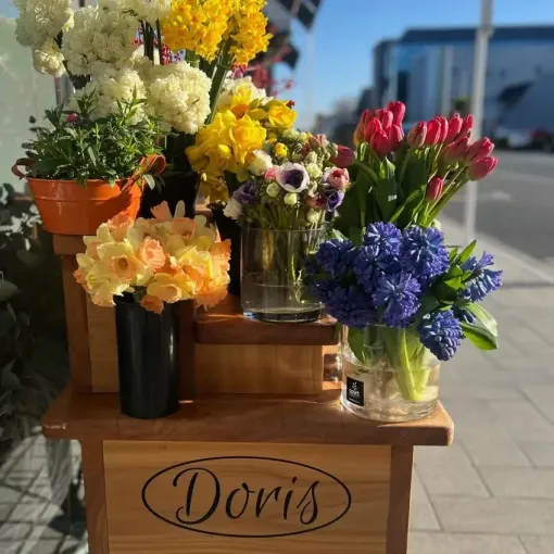 A wooden flower cart with the name Doris on it outside the Court Florist in Christchurch on Victoria Street
