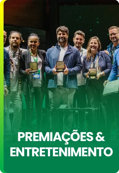 Um grupo de pessoas em pé, sorrindo enquanto seguram pequenos prêmios, sob a inscrição