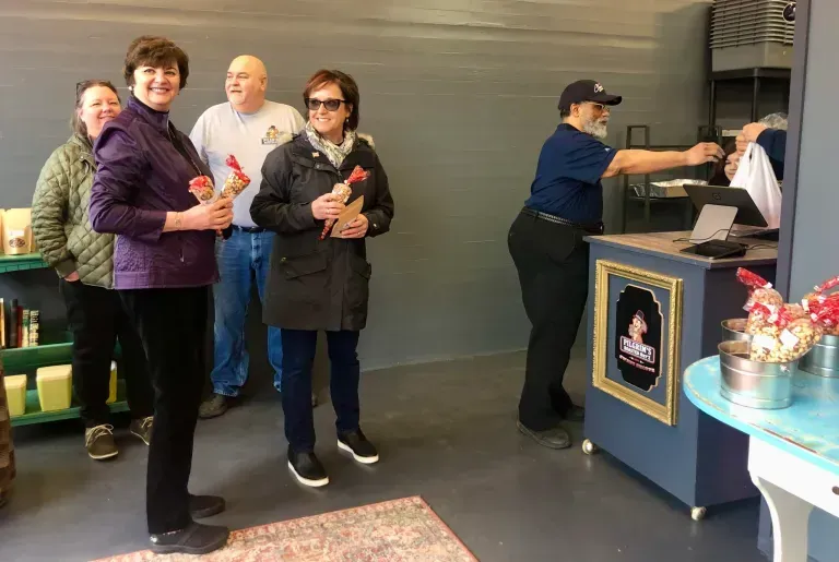 A group of people are standing in front of a counter in a store.
