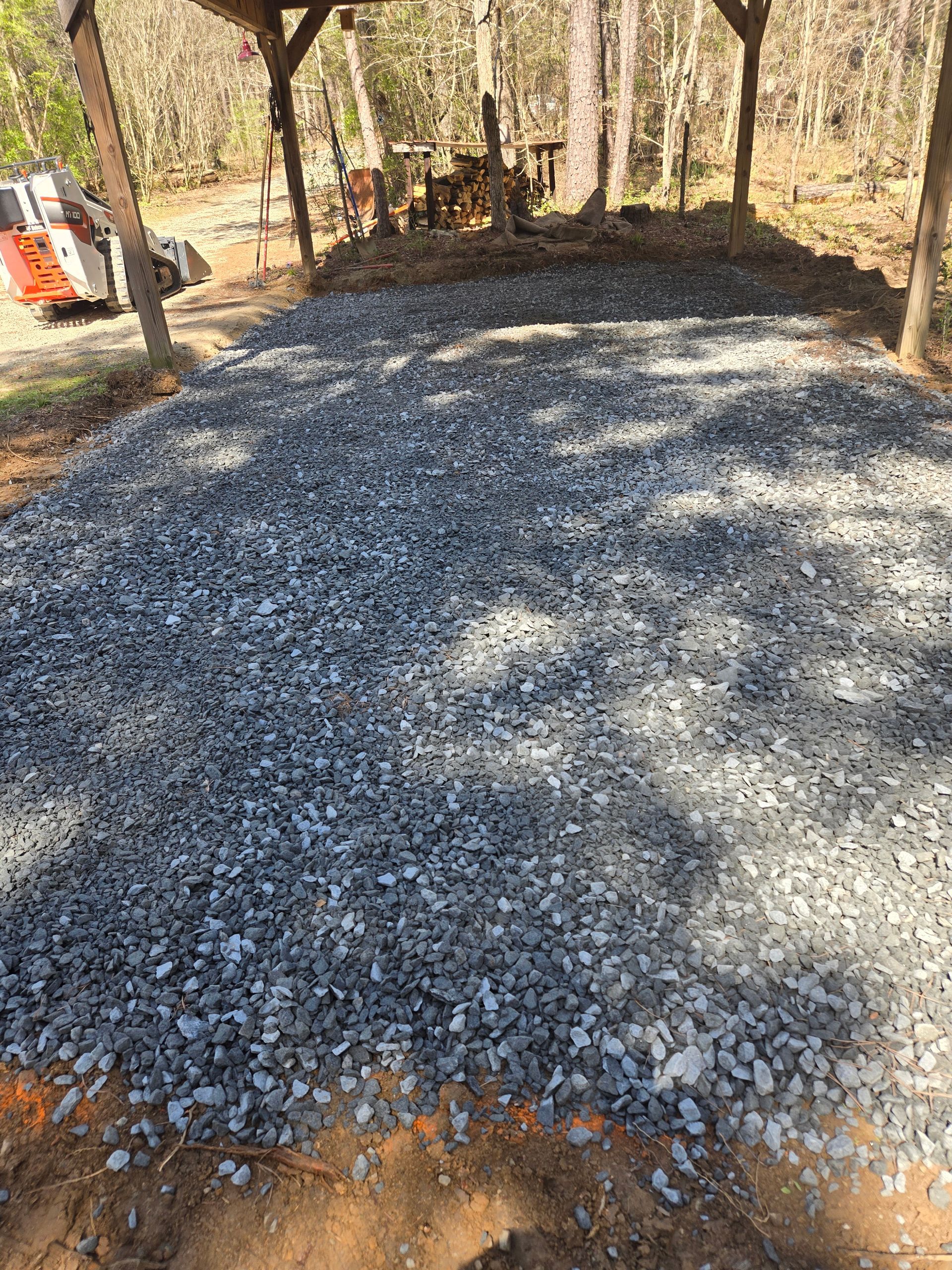 A drain is being installed in the dirt next to a patio.