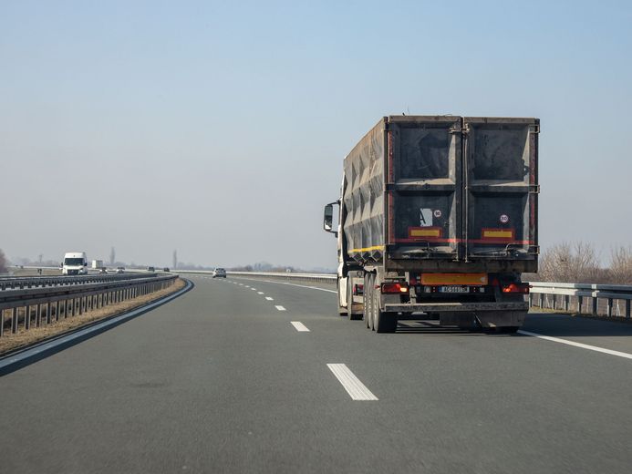 Truck driving on an open highway under a clear sky