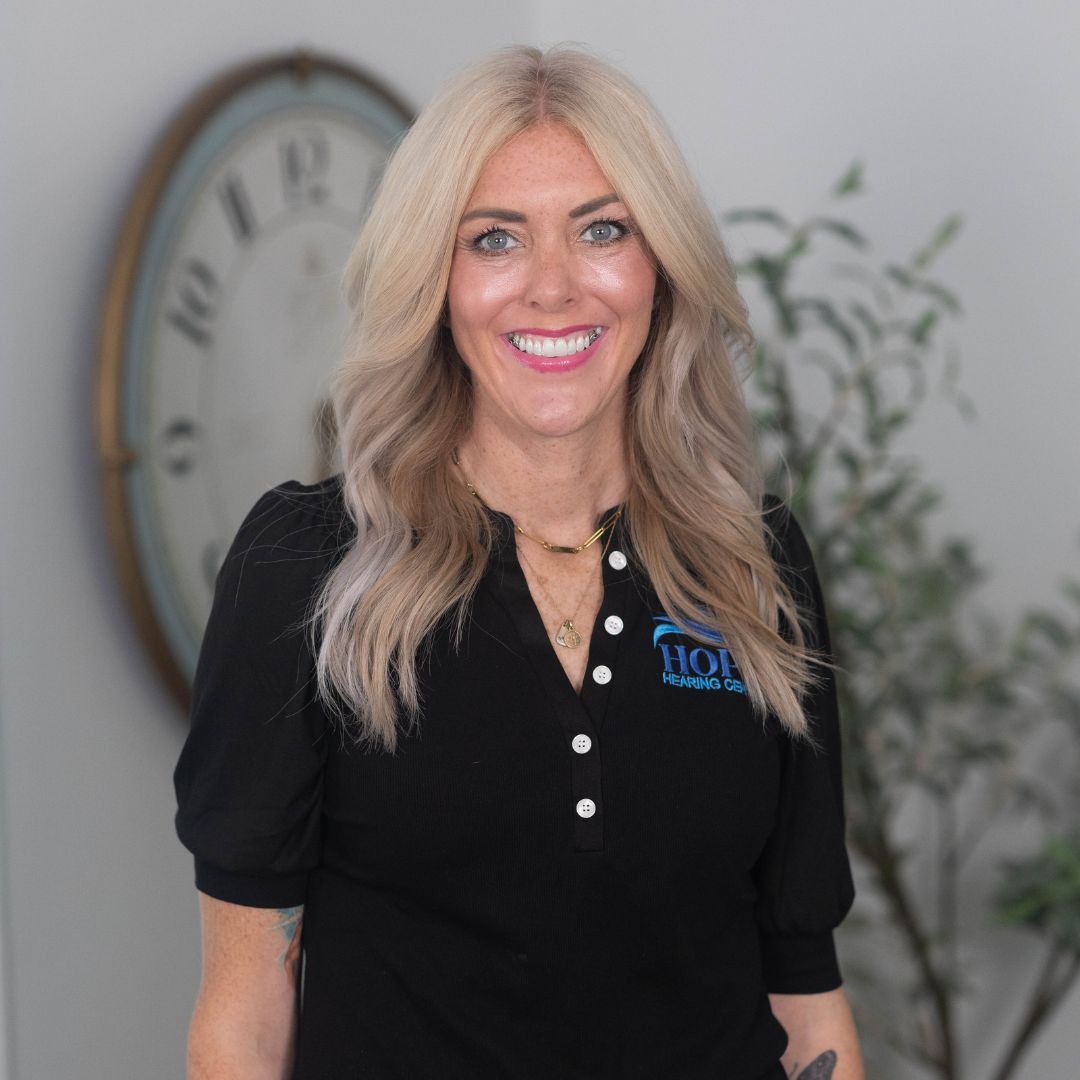 A woman wearing a black t-shirt with an 88 on it is smiling for the camera.