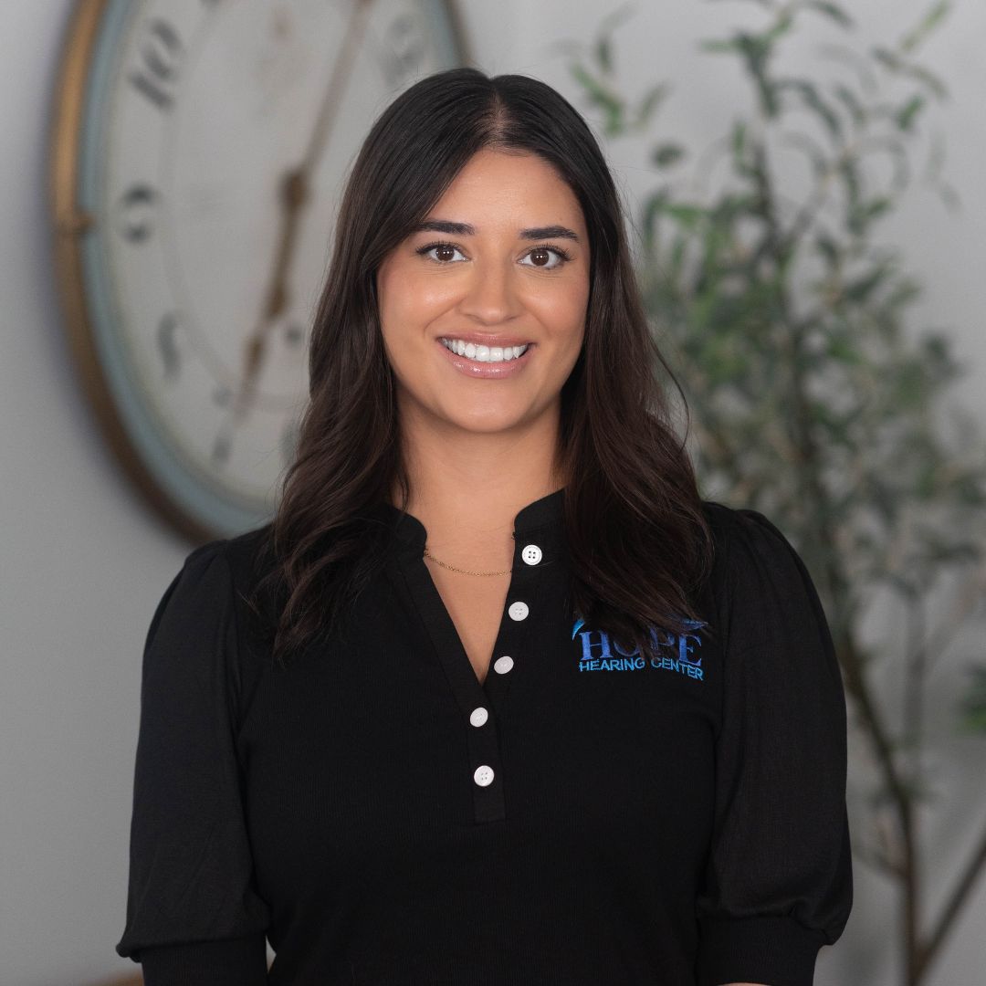A woman in a black shirt is smiling for the camera.