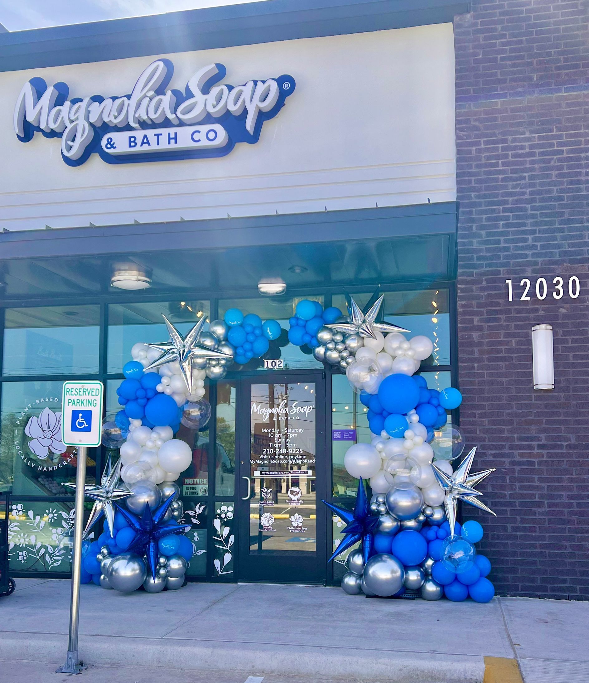A store front decorated with blue and silver balloons