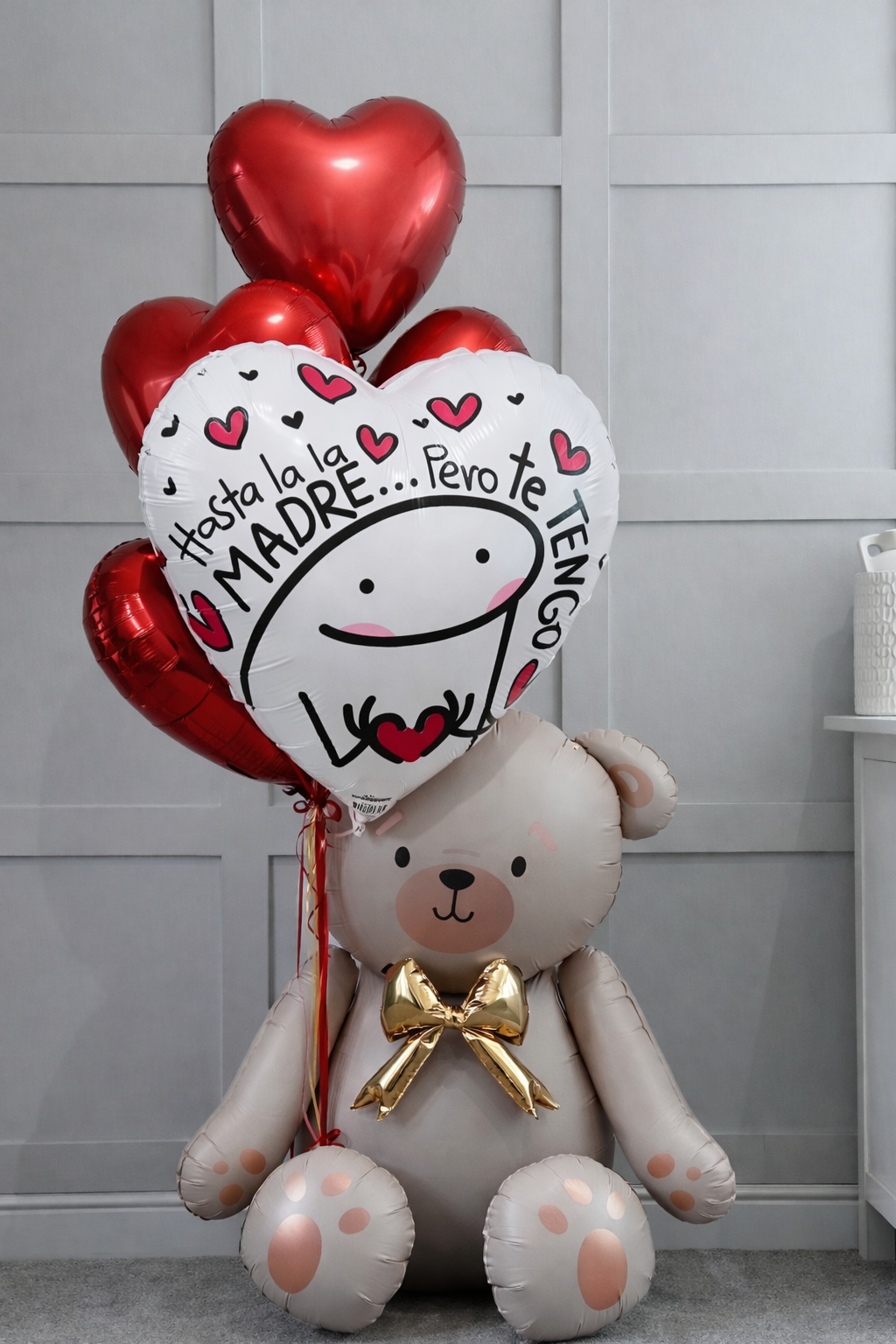 A sitting teddy bear balloon bouquet with red heart balloons and one white heart balloon featuring a Flork meme character.