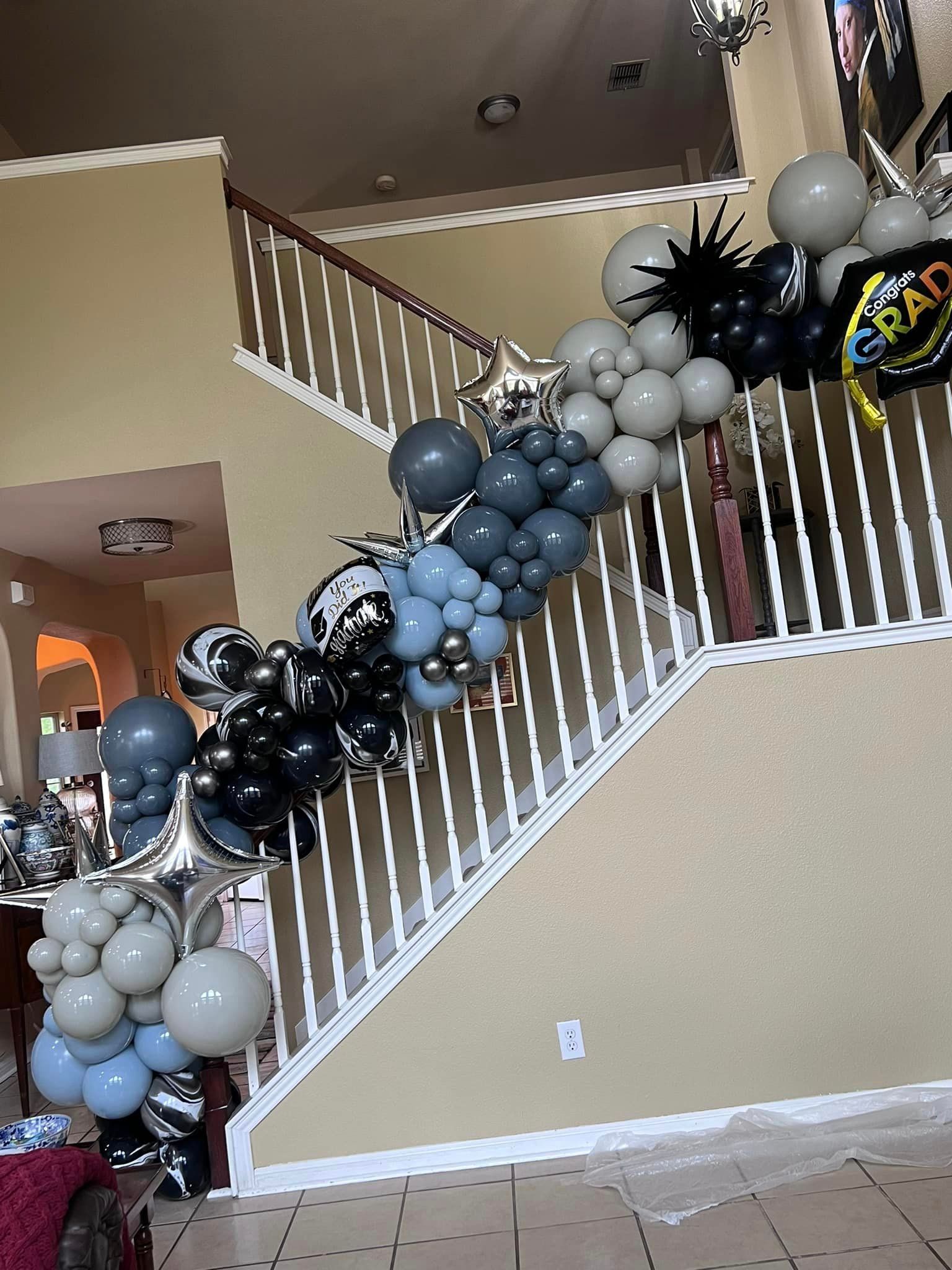 A staircase decorated with balloons for a graduation party.