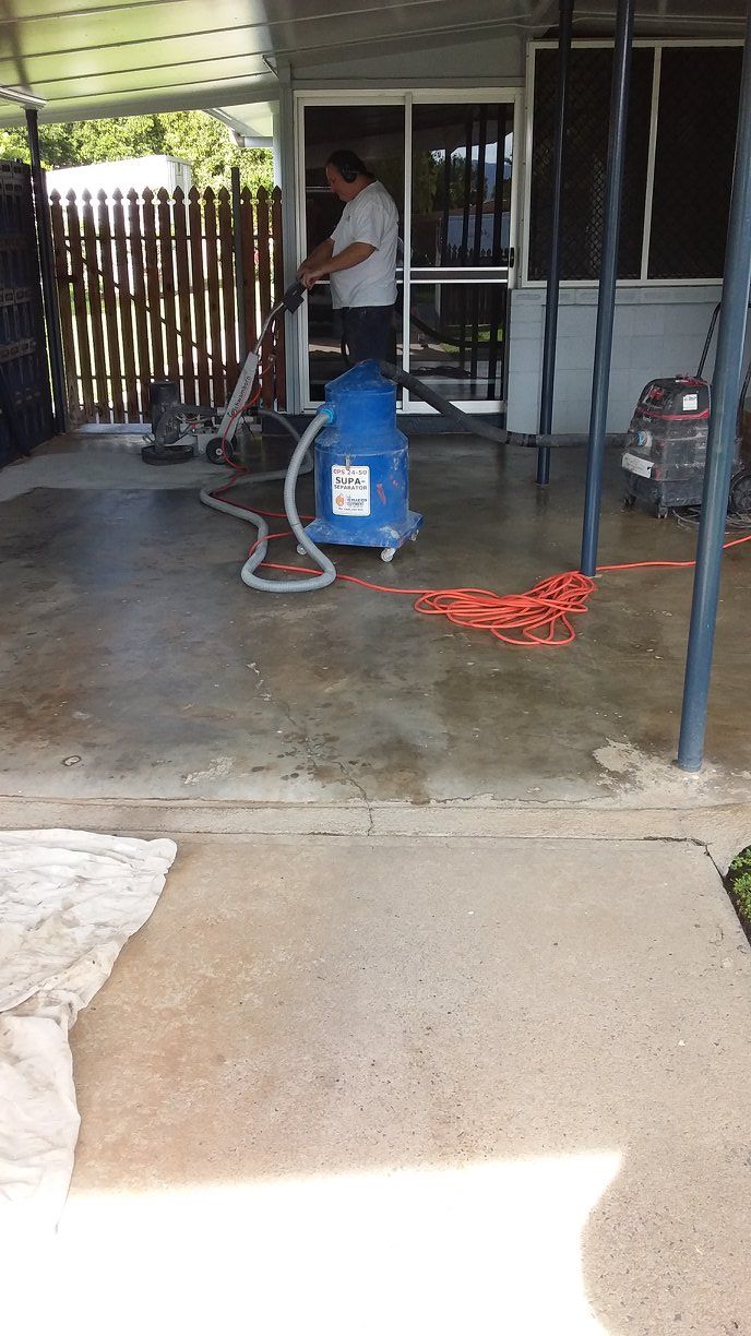 Man is Cleaning a Concrete Patio With a Vacuum Cleaner — Australian Epoxy Floors in Rockhampton, QLD