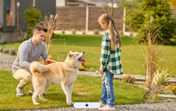 A beautiful wooden backyard fence surrounding a landscaped outdoor living area with children playing