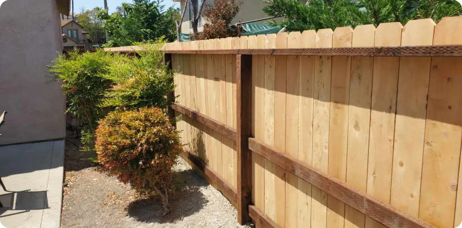 The Fence Company fence construction, Fresno, CA, installing a natural wood privacy fence along the 