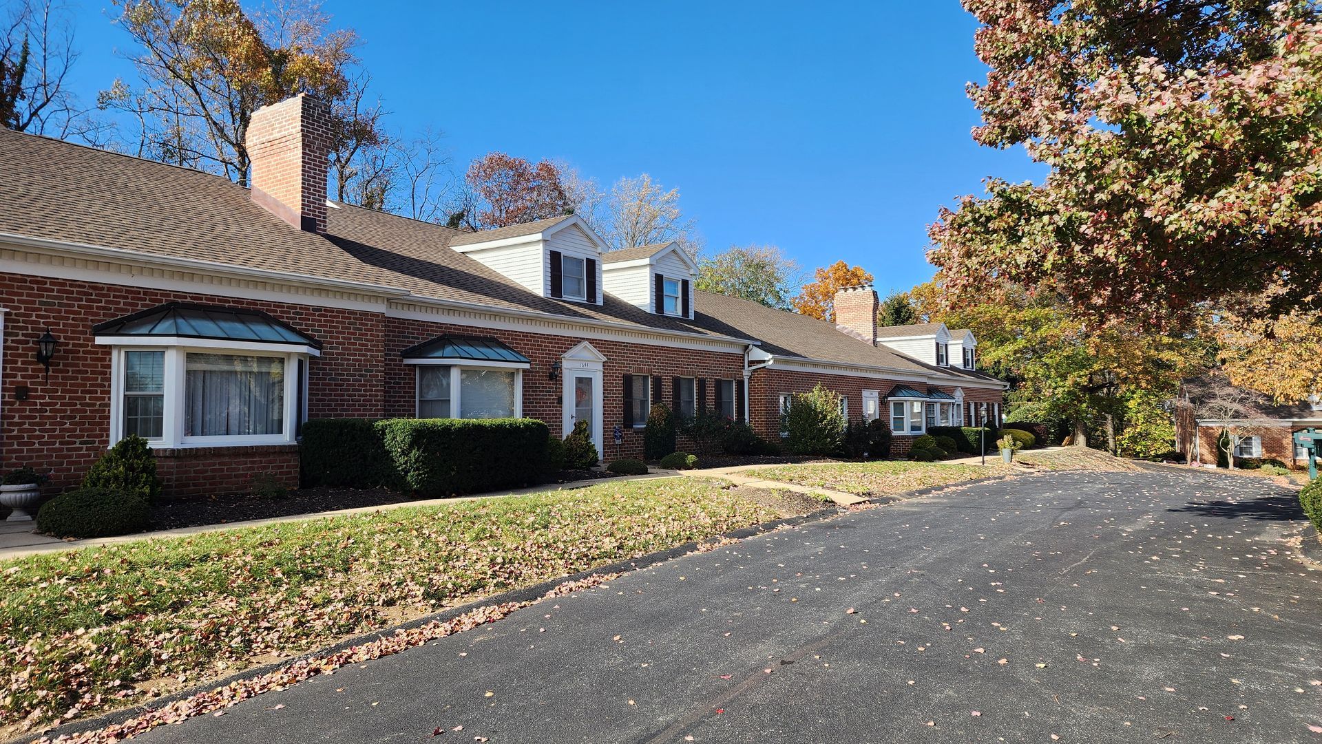 A row of brick houses are lined up on a sunny day