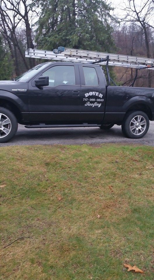 Black pickup truck with ladder — Mount Wolf, PA — Dover Roofing Services