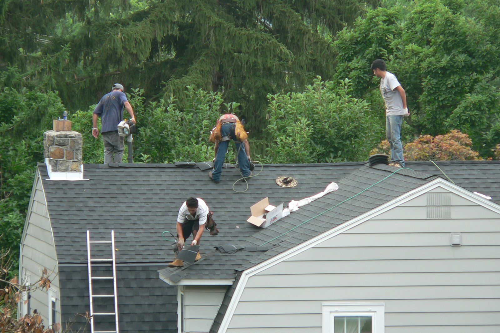 Four workers repairing the roof — Mount Wolf, PA — Dover Roofing Services