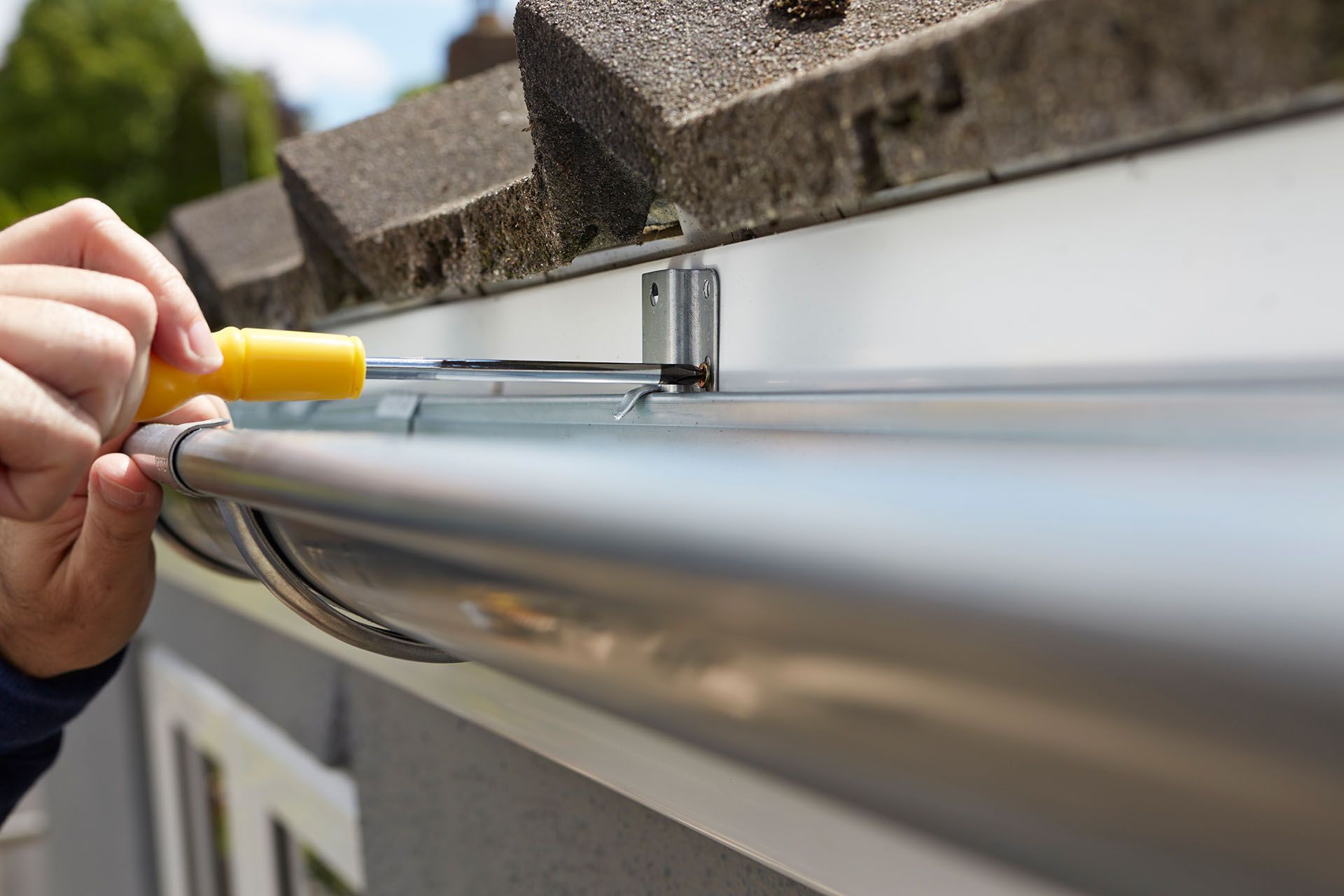 Close-up of man replacing gutter — Mount Wolf, PA — Dover Roofing Services