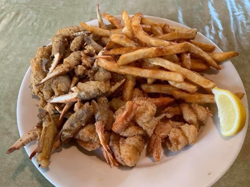 Plate of fried seafood and French fries with a lemon wedge on the side