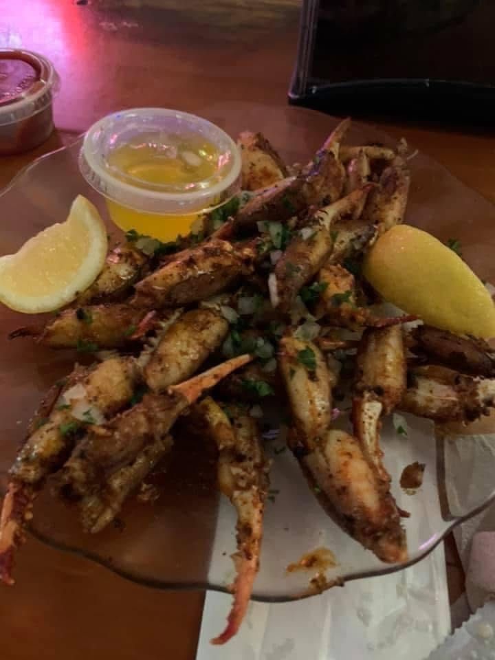 Plate of grilled seafood with lemon wedges and dipping sauce on a restaurant table