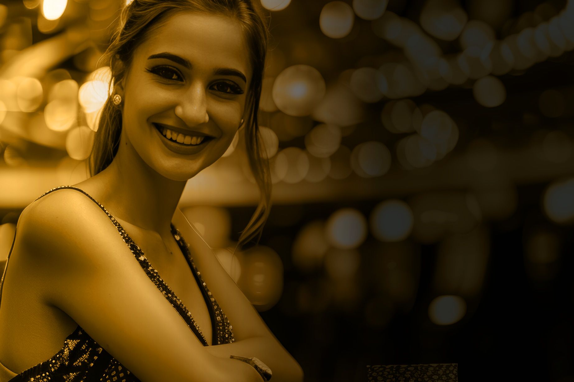 A woman in a dress is smiling and looking at the camera.