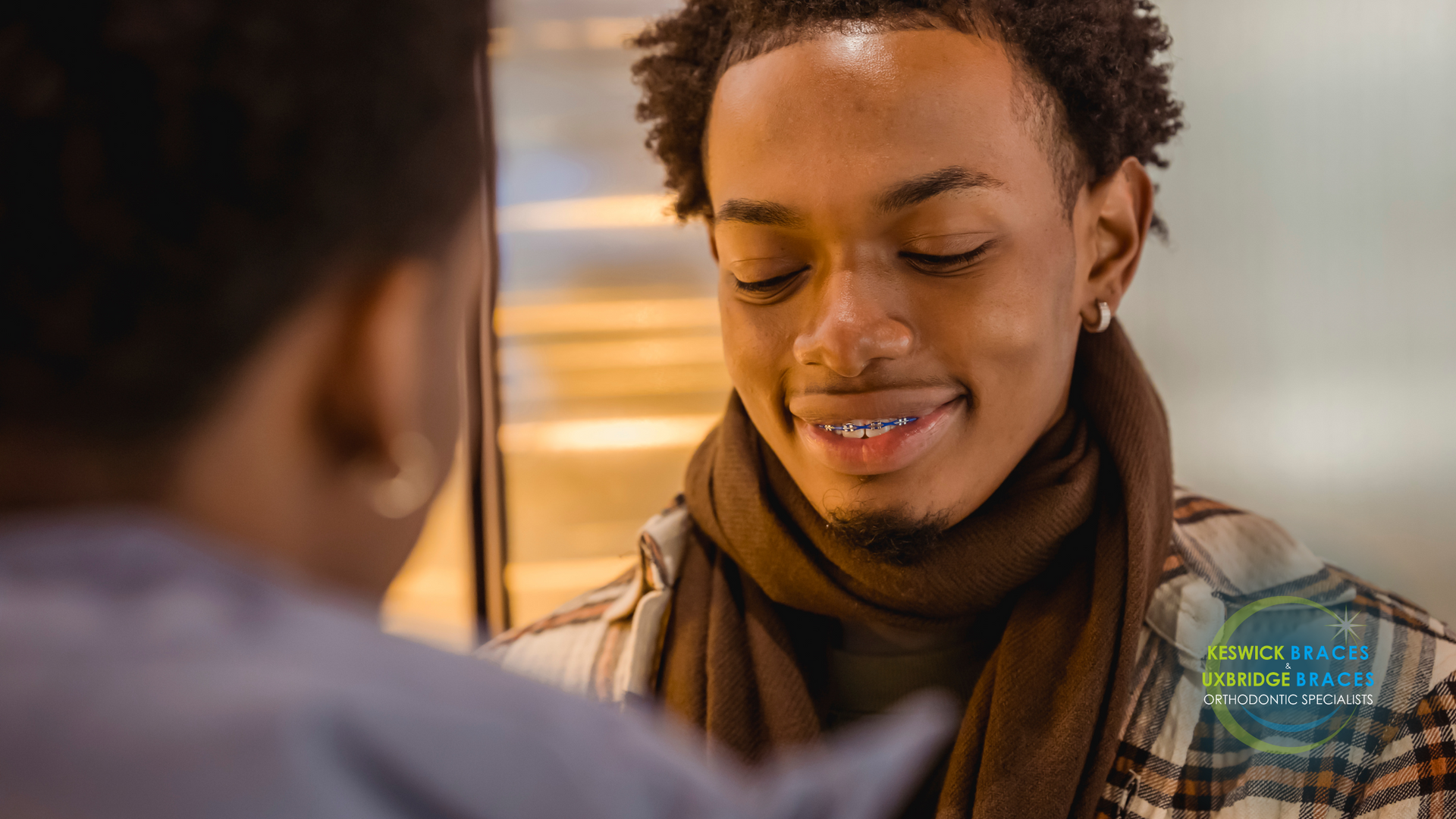 A young man is looking at himself in the mirror and smiling.