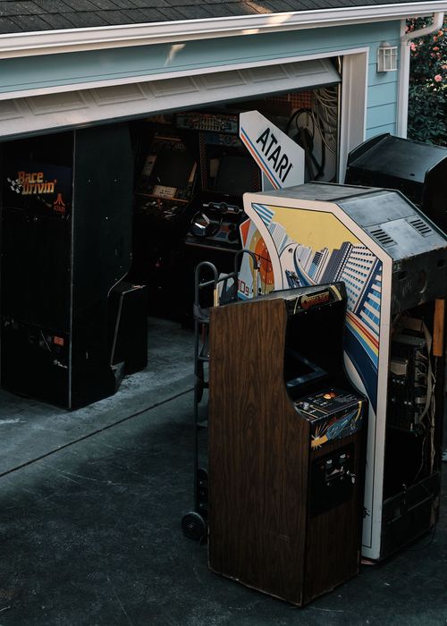 Outdoor scene with an overturned arcade cabinet and scattered equipment in a driveway