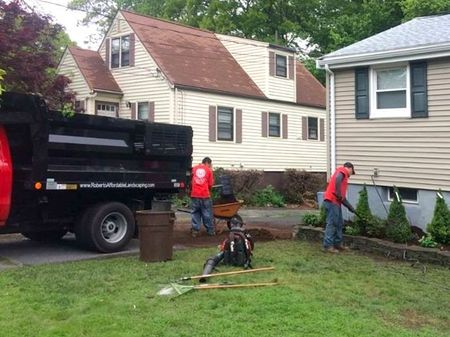 A white utility truck is parked on the side of the road in front of a house.