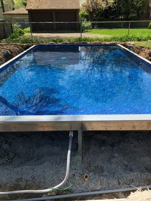 A swimming pool is being built in a backyard.