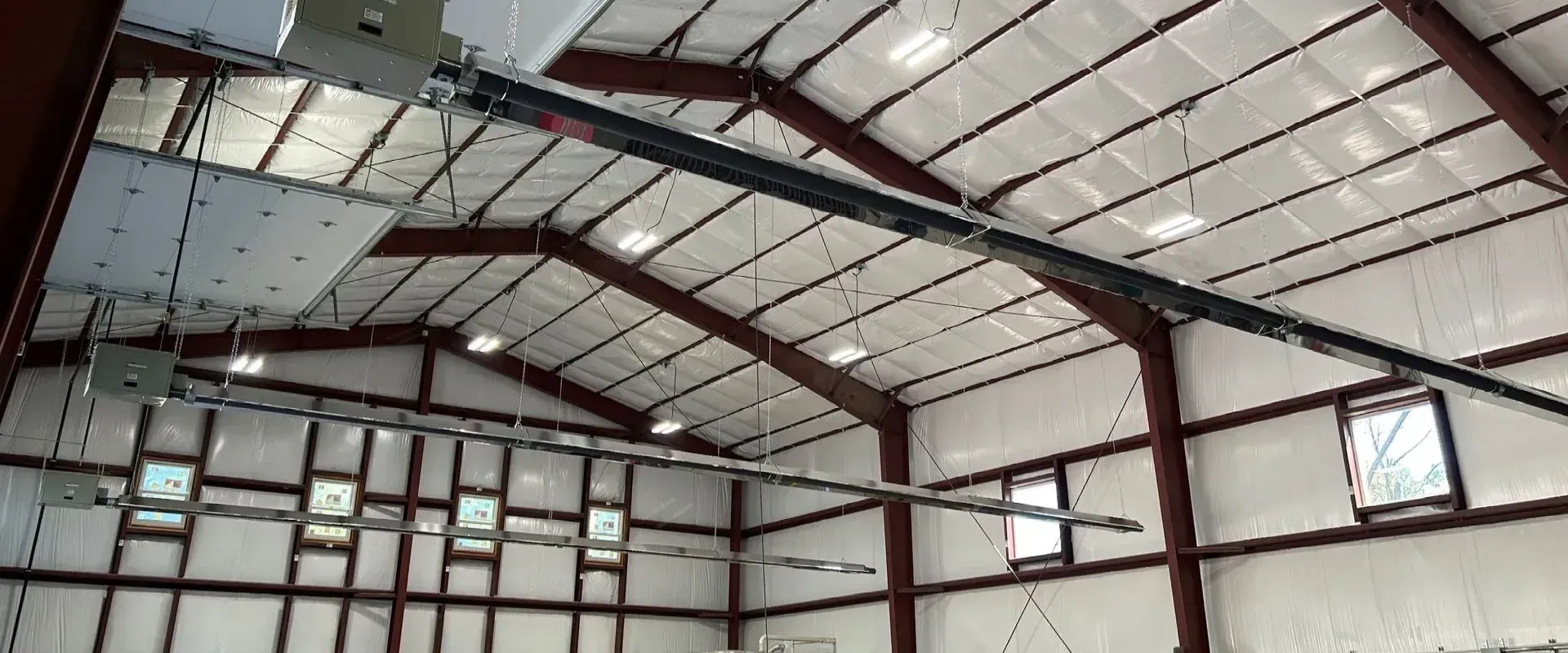 A large metal building with a ceiling fan hanging from it.