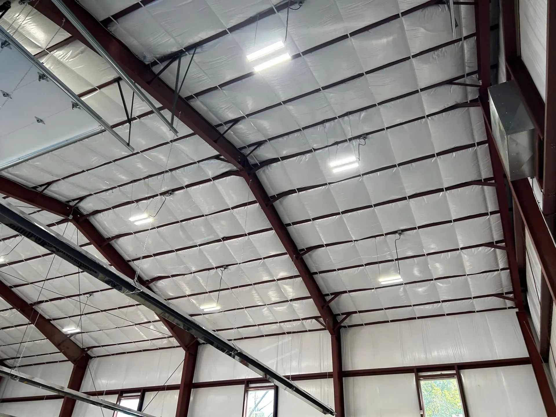 The ceiling of a building with a lot of lights hanging from it.