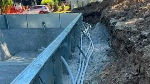 A bunch of wires are coming out of a hole in the ground