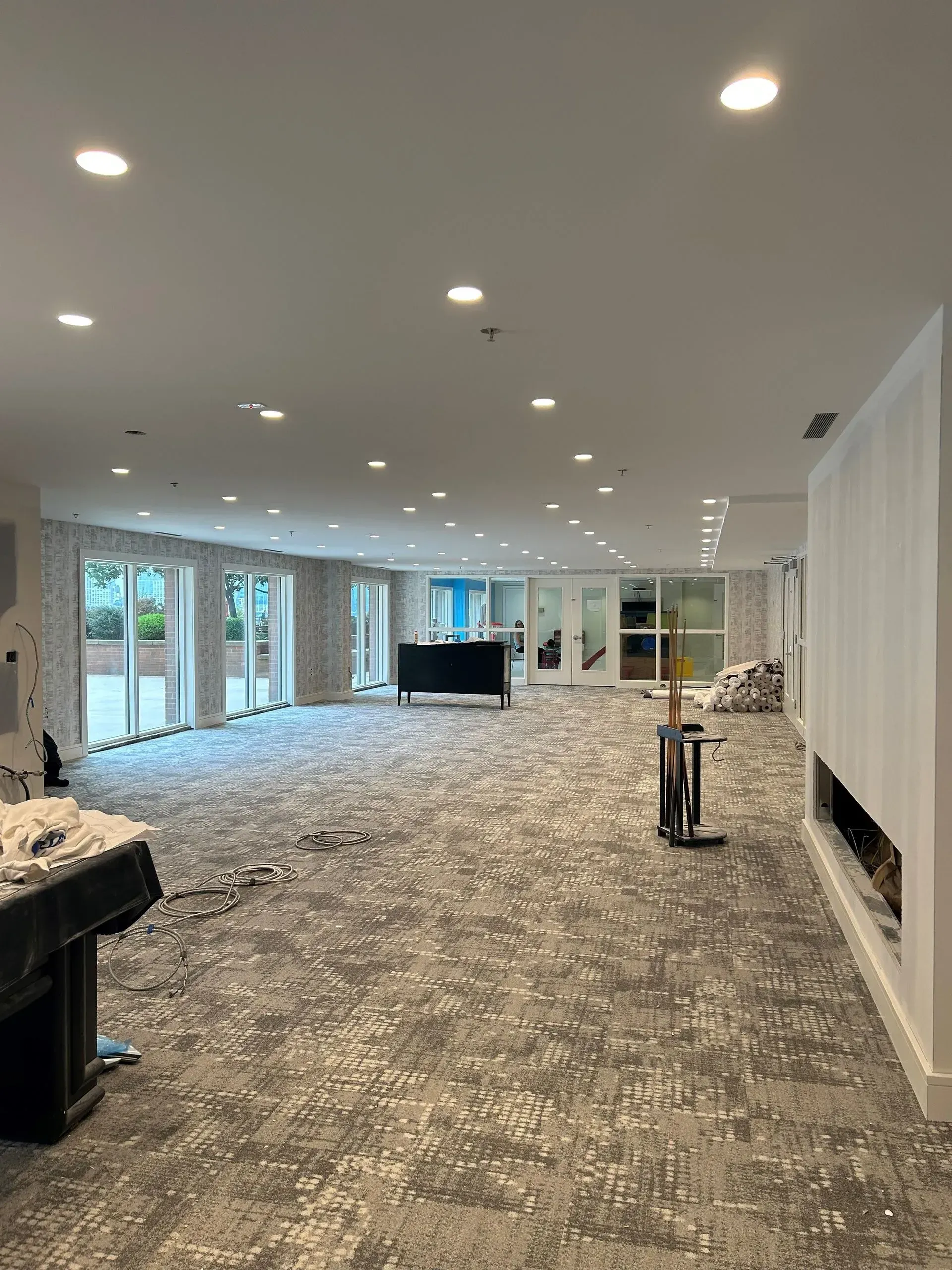 A large room with a lot of windows and a carpeted floor.