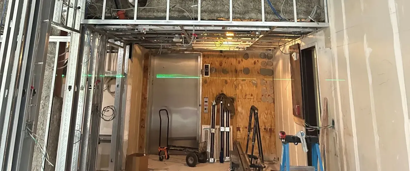 A building under construction with a ladder in the middle of the room.